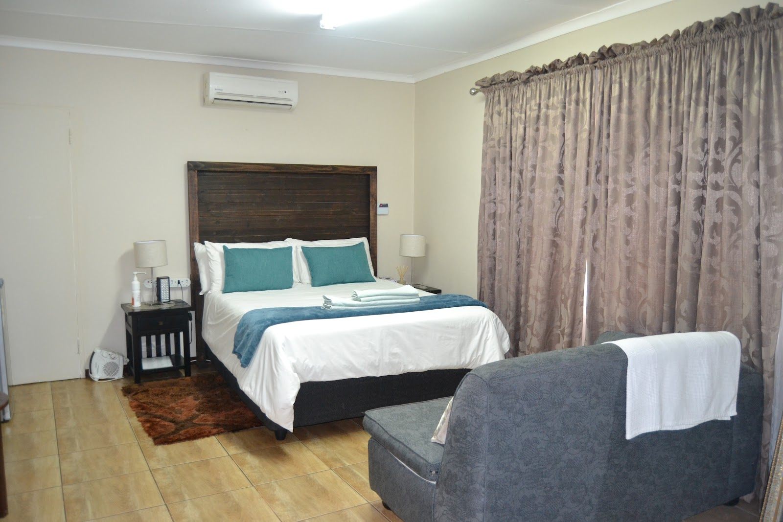 Queen room with air-conditioning and sofa at Green Grove Villa